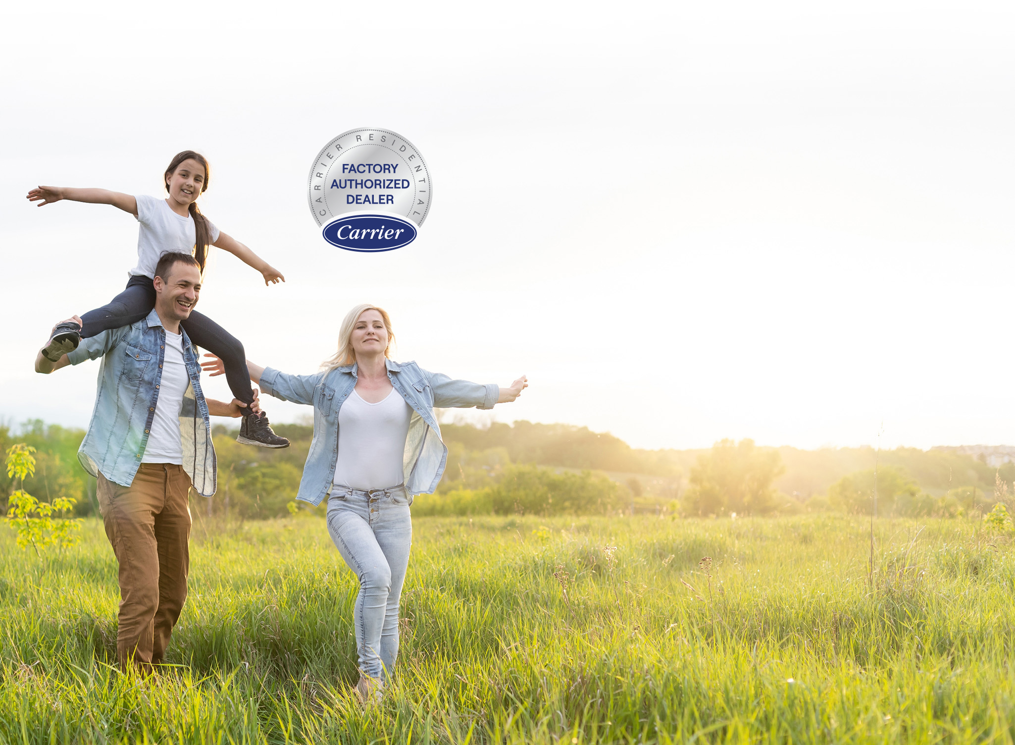 Family happily running through a field of green grass.