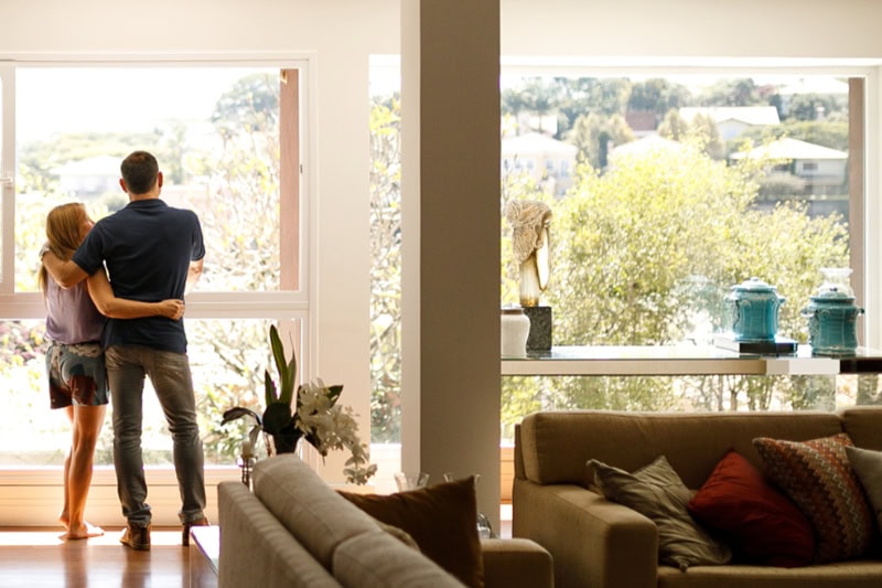 Couple admiring the view from the living room of their house.